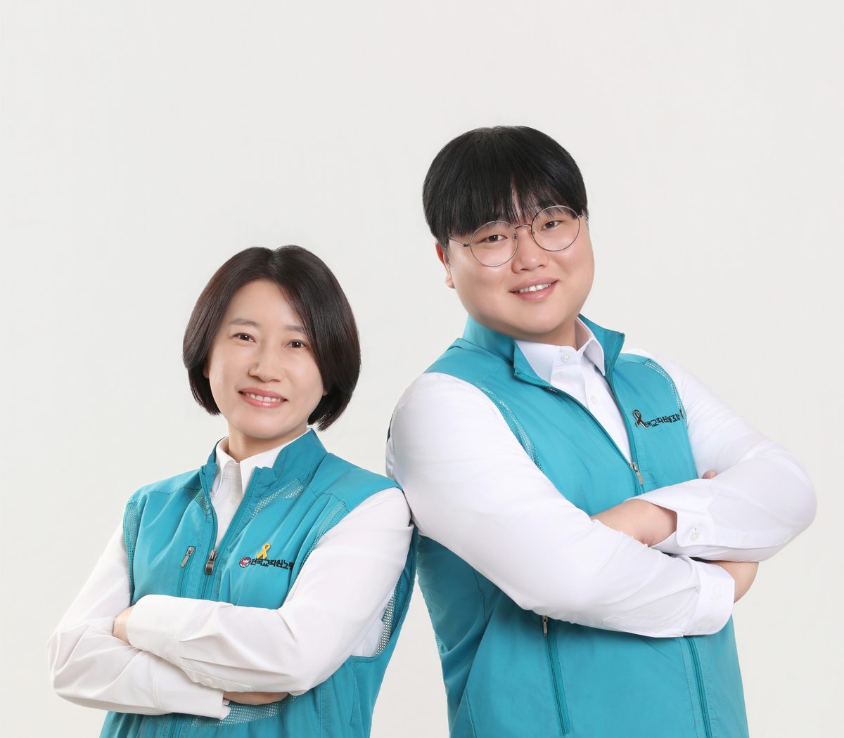 청록 조끼를 입고 나란히 선 두 후보